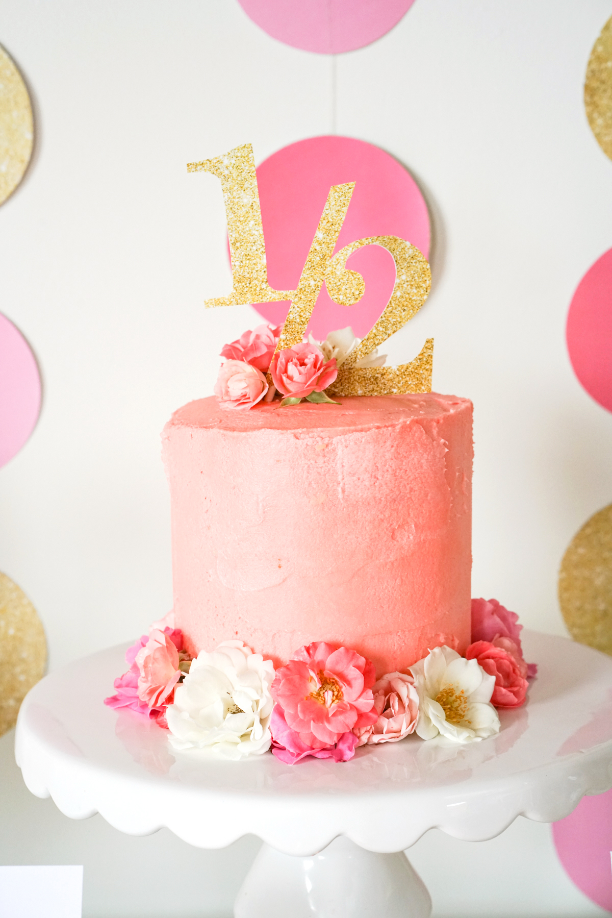 Printable Half Birthday Gold Glitter Cake Topper on top of a pink buttercream cake with pink roses to embellish