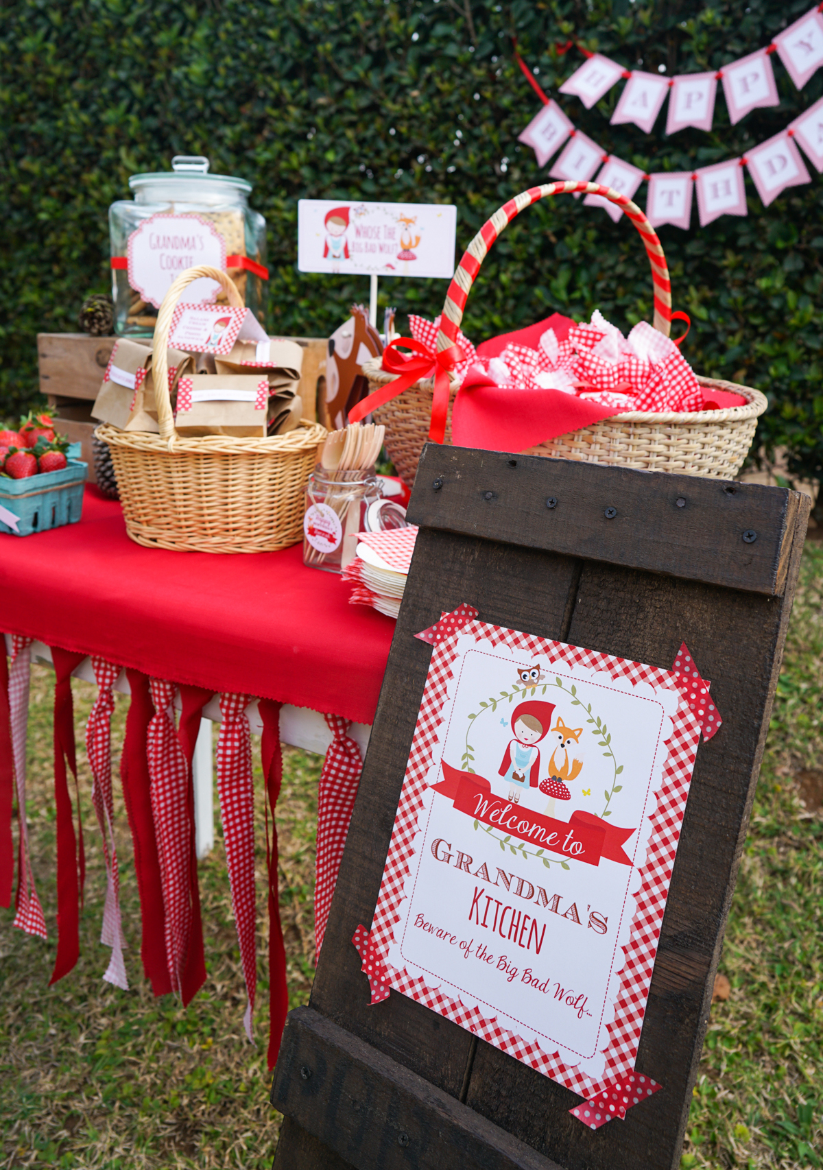 Little Red Riding Hood Party Table with a red table cloth and red gingham bunting adorned with sweet and party treats