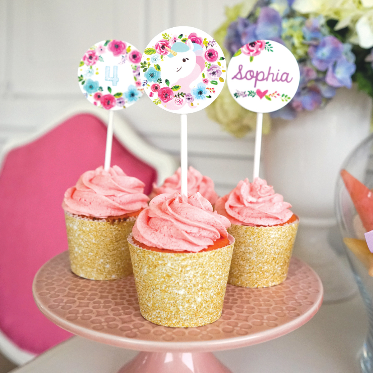 Three gorgeous cupcakes with gold glitter wrappers and editable unicorn cupcake toppers.